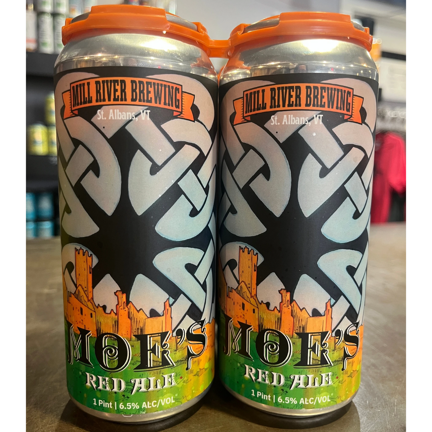 Stowe Public House & Bottle Shop: Mill River Brewing Moe's Irish Red Ale cans with castle and Celtic knot design.
