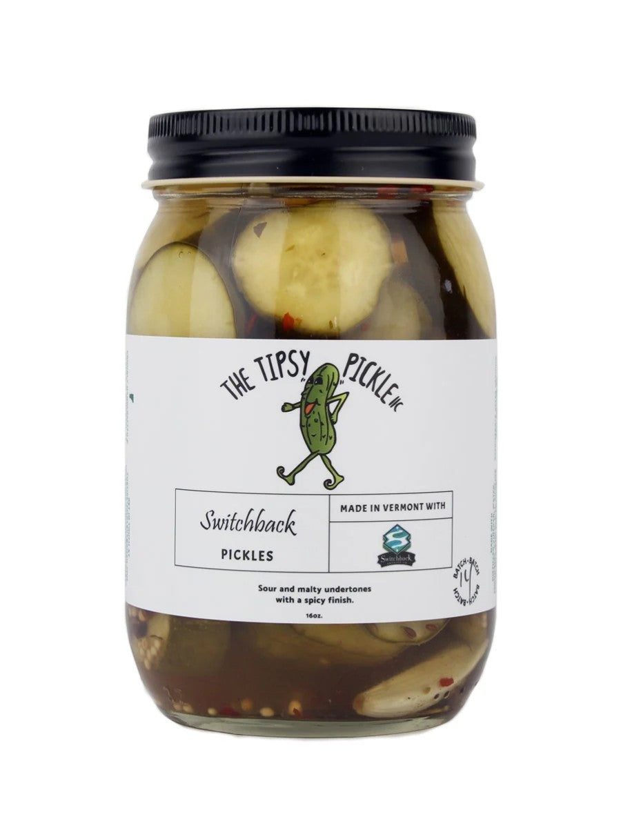 Stowe Public House & Bottle Shop's Tipsy Pickle, Switchback pickles in a glass jar with a black lid. Sliced pickles with dill, garlic, and chili flakes in brine.