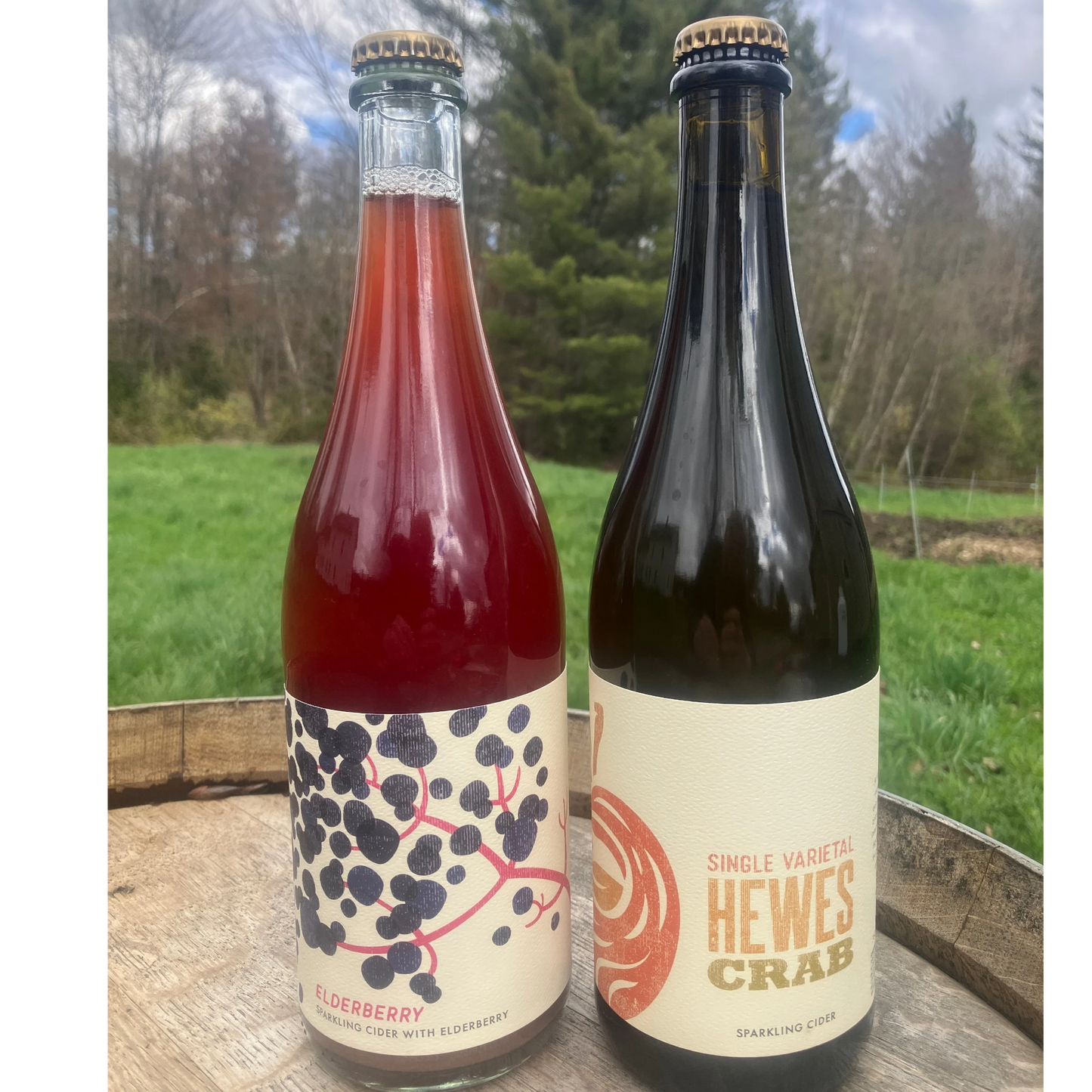 Stowe Public House & Bottle Shop Wildbranch Cider, Elderberry sparkling cider with elderberry, deep red color, on a wooden barrel outdoors.
